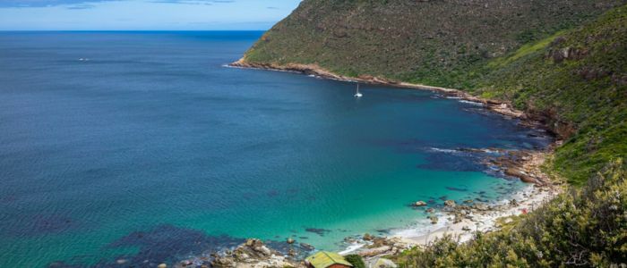 Scenic view of Cape Town's coastline, featuring sandy beaches and the iconic Table Mountain in the background.