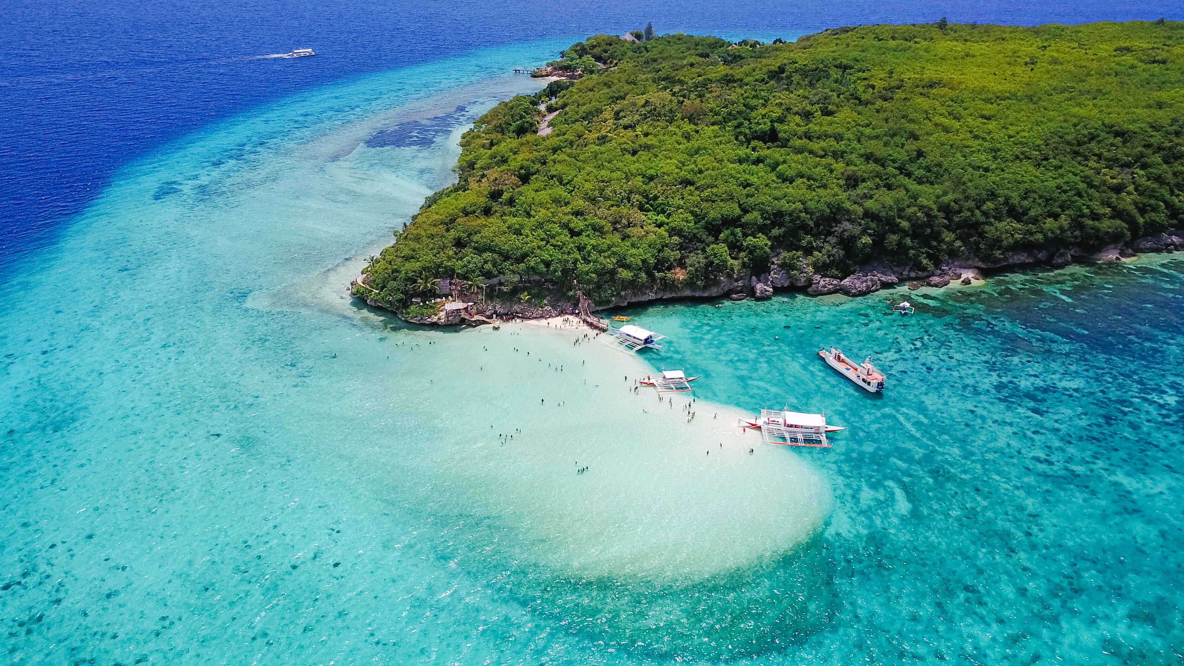 aerial-view-sandy-beach-with-tourists-swimming-beautiful-clear-sea-water-sumilon-island-beach-landing-near-oslob-cebu-philippines-boost-up-color-processing 
