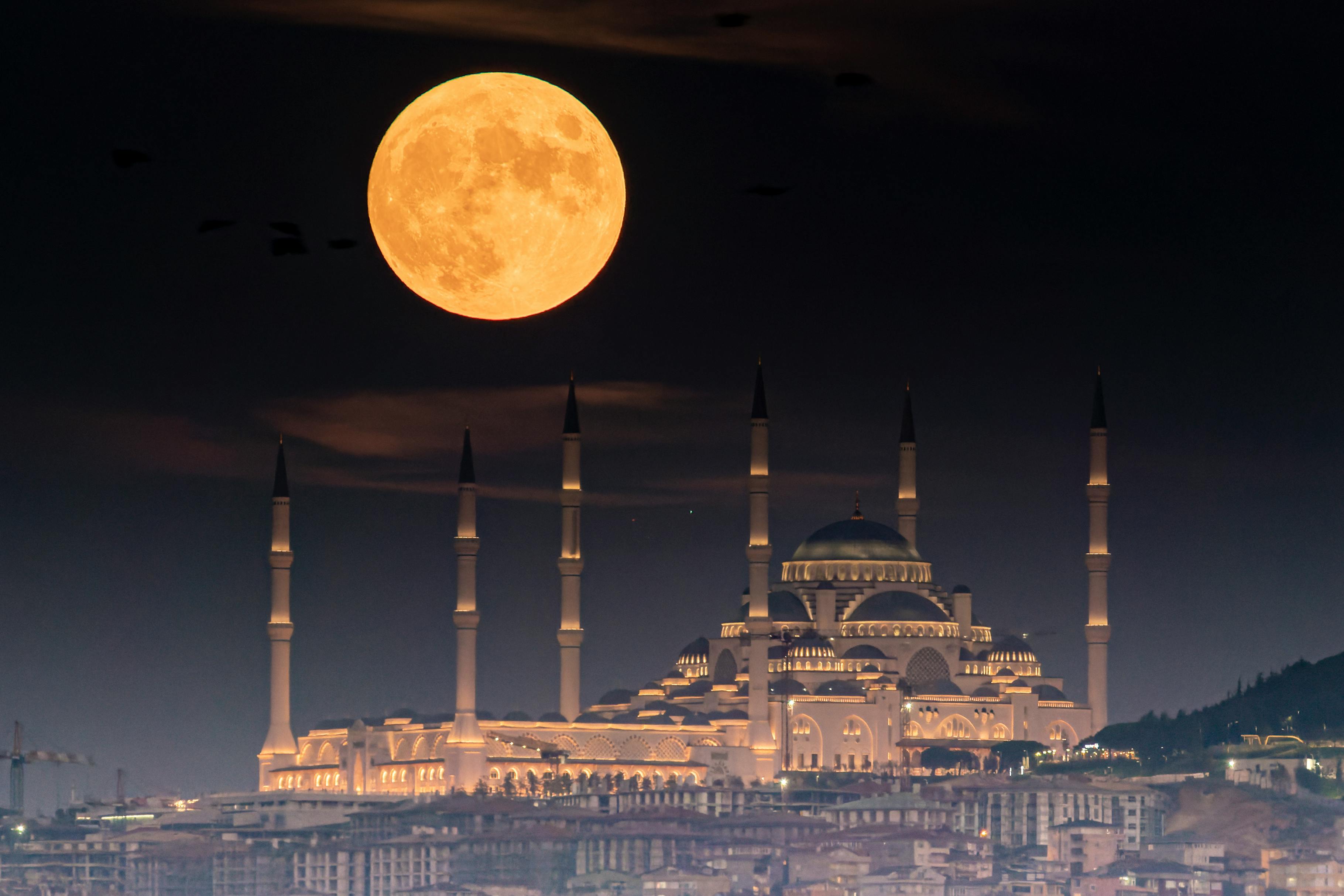 blue mosque at night with big moon
